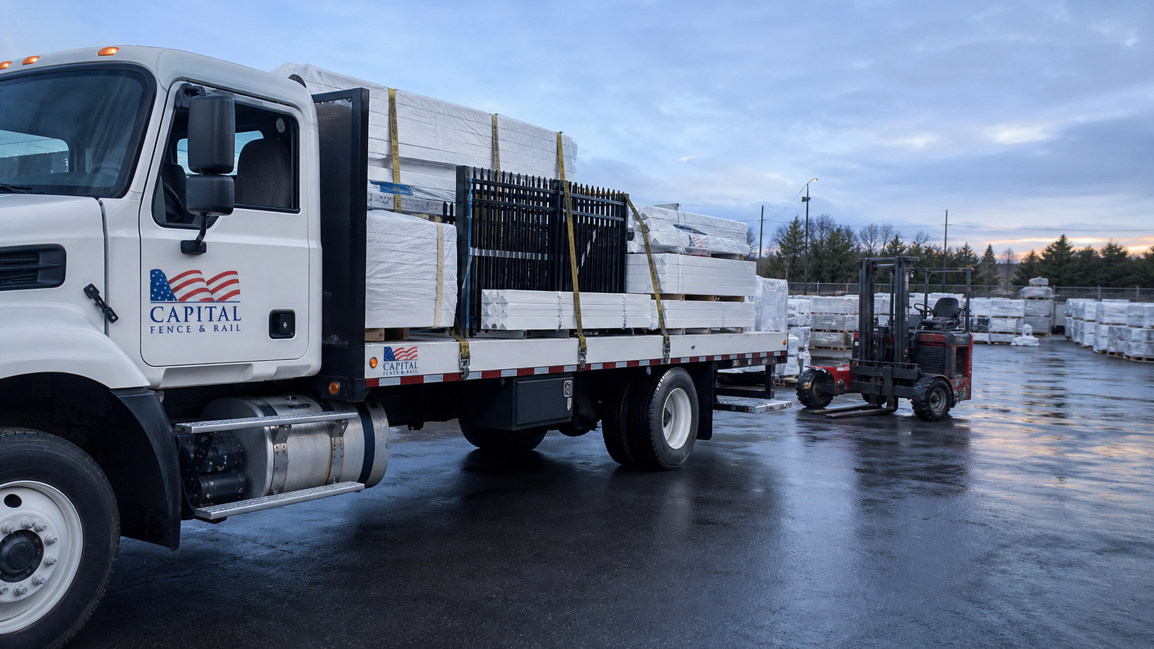 Capital Fence and Rail flatbed truck loaded with bundled fence and railing material beside a forklift