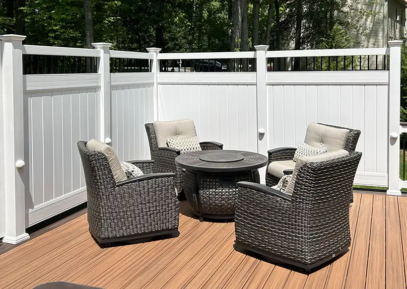 White privacy fence with dark framed spindles around a furnished deck
